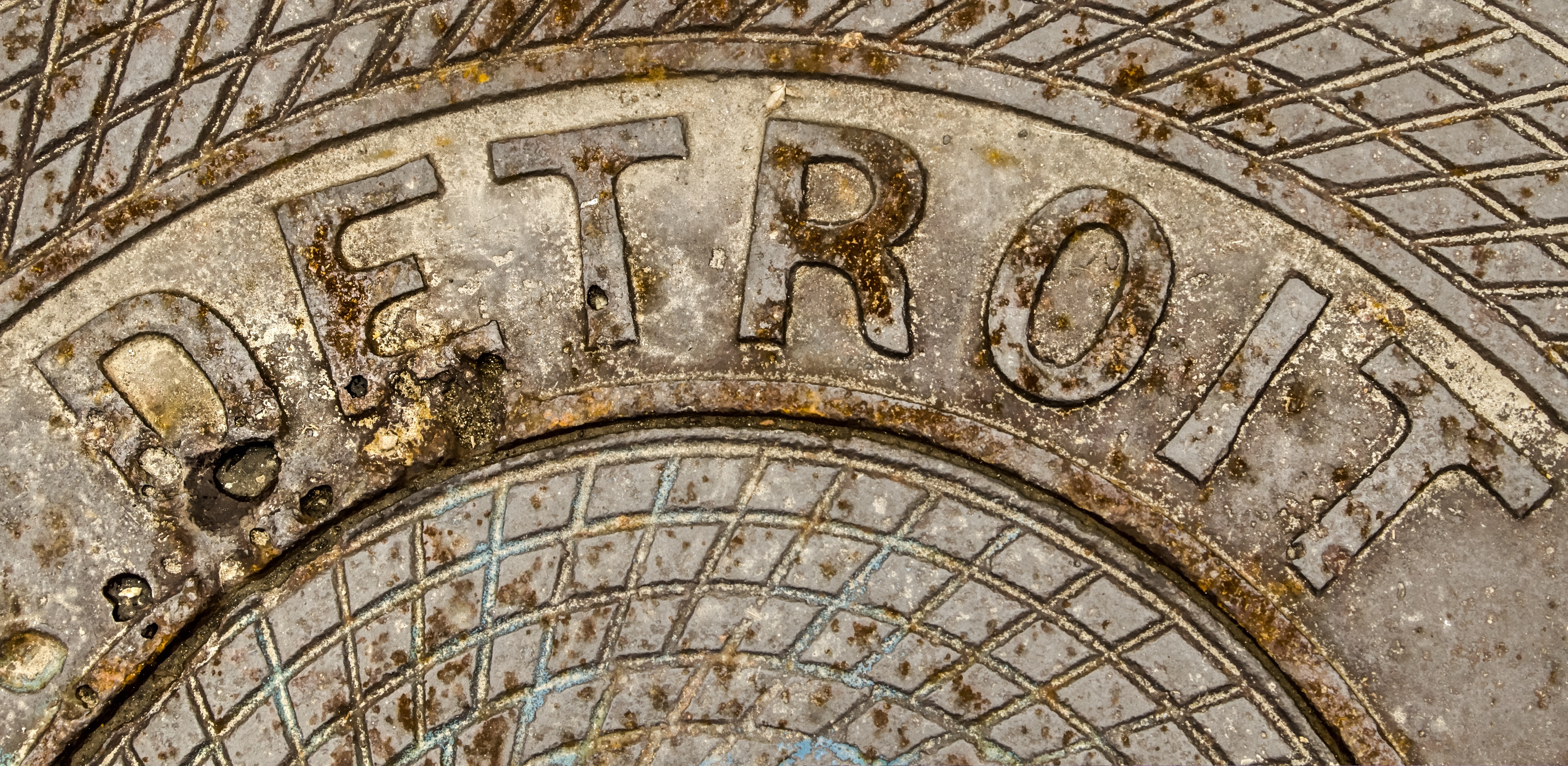 Detroit Michigan Background. Rusty manhole cover with the word Detroit engraved on it.